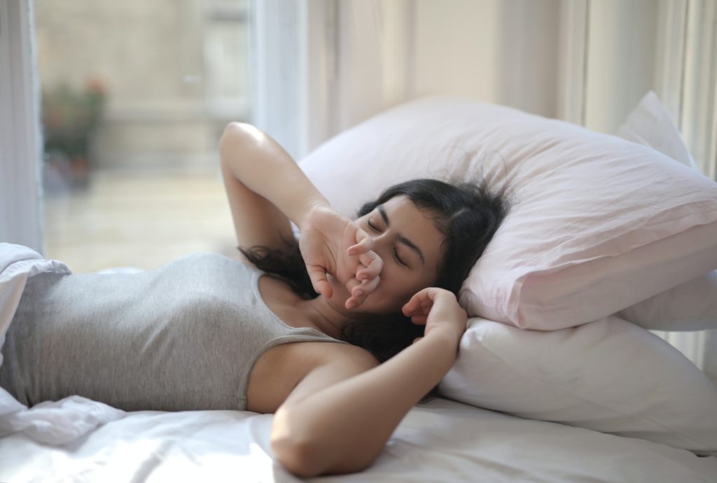 Woman in Gray Tank Top Lying on Bed