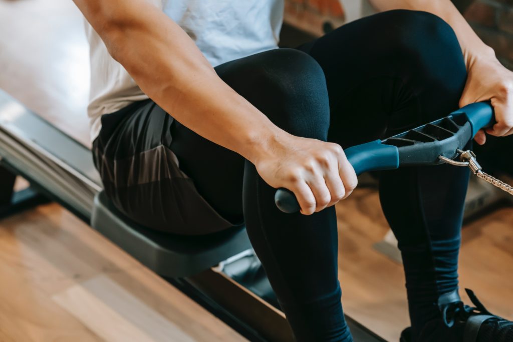 Fit man doing exercises on rowing machine