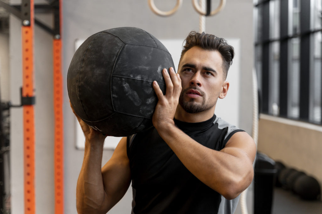 attractive-fit-man-working-out-indoors-with-exercise-ball