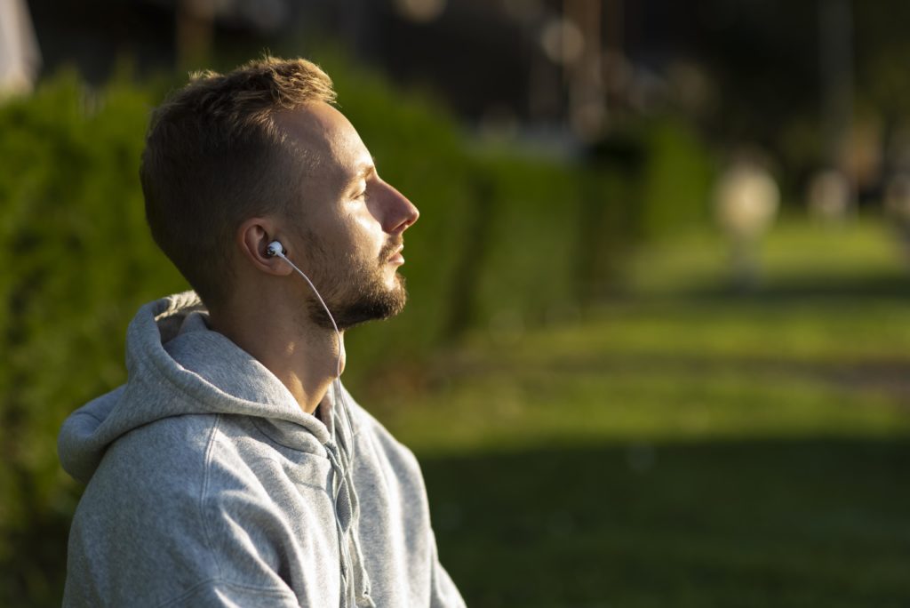 Sideways man listening to music while meditating