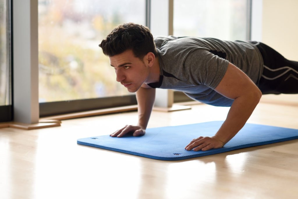 Attractive man doin pushups in the gym