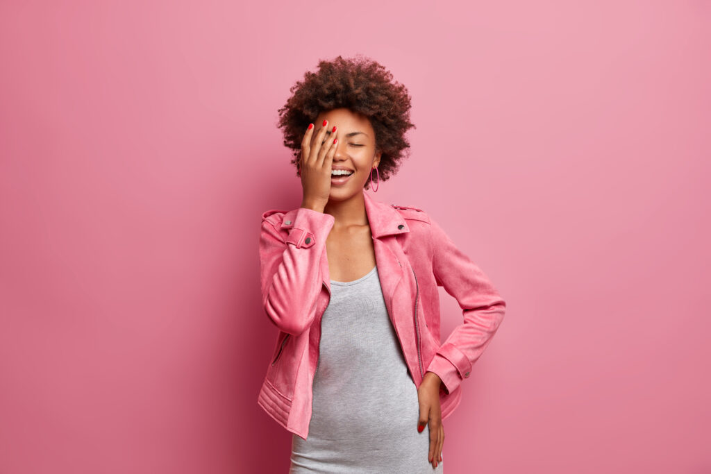 Happy afro american woman laughing, facepalm gesture