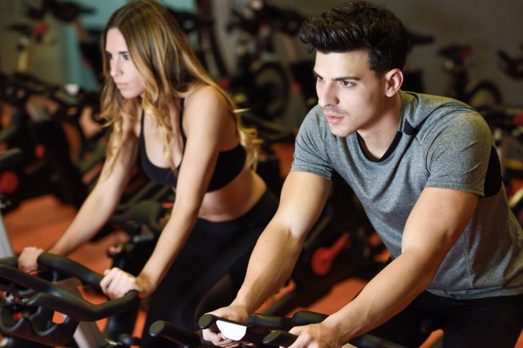 Couple in a spinning class wearing sportswear.